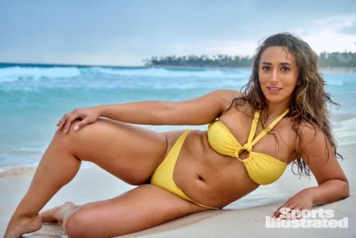 Sarafina El-Badry Nance lays on the sand in a yellow bikini.
